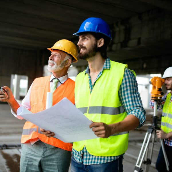 Engineer, foreman and worker discussing in building construction site